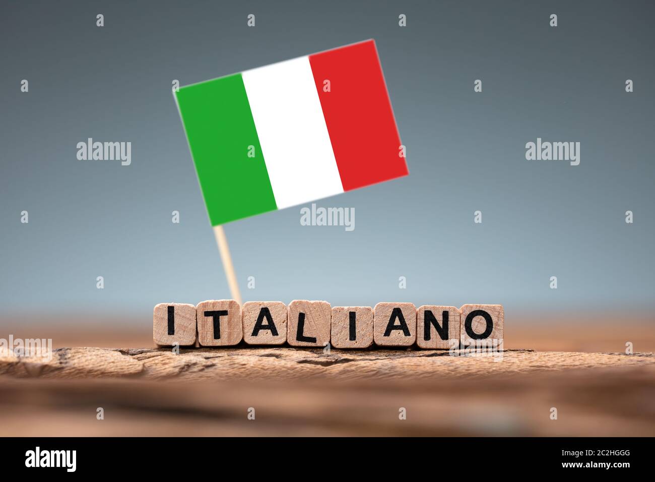 Italian Word Formed Using Wooden Block And Flag On Desk Stock Photo - Alamy