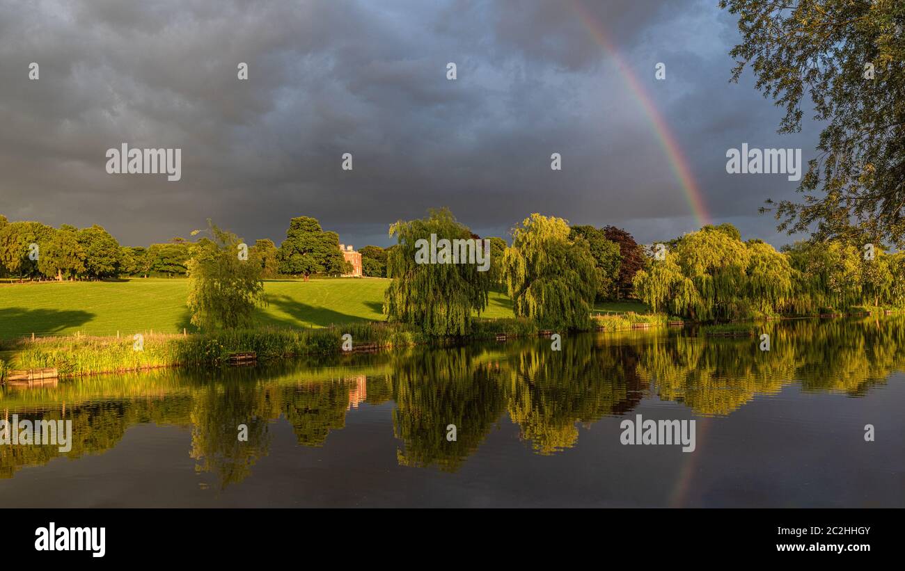 Wedgwood pools and Barlaston Hall. A landscape view with sunlight, stormy sky and rainbow reflected in the water Stock Photo