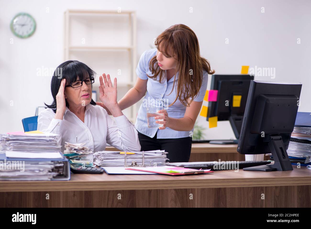 Two employees and excessive work in the office Stock Photo