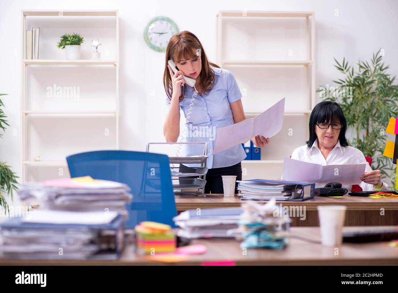 Two employees and excessive work in the office Stock Photo