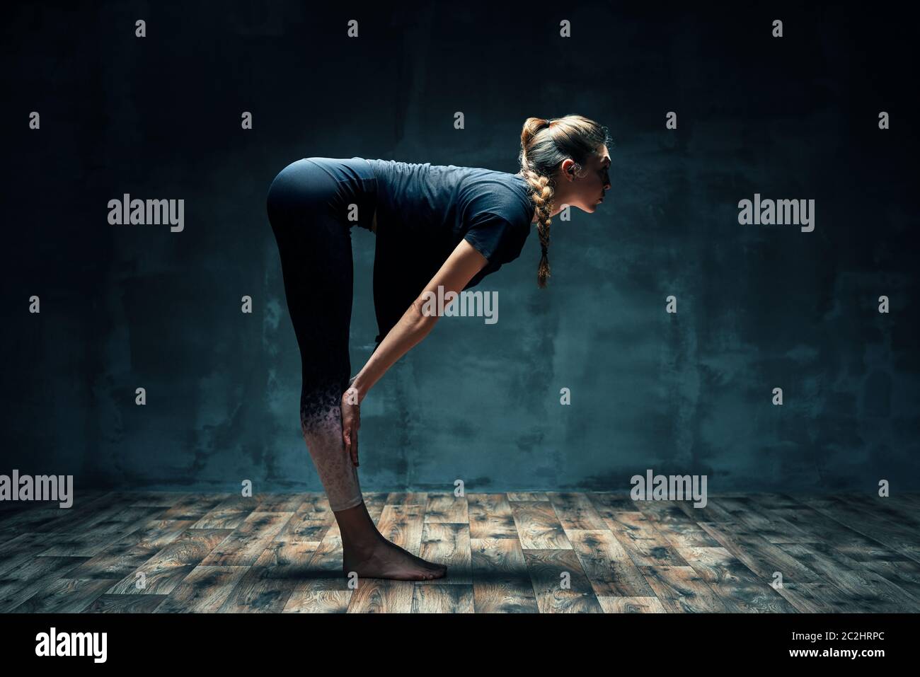 Young beautiful woman doing yoga asana half chair pose on dark room.  Practicing yoga, wellbeing and healthy lifestyle. Ardha utkatasana Stock  Photo - Alamy