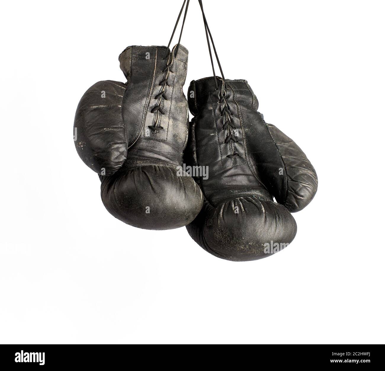 pair of very old vintage black leather boxing gloves hanging on a rope