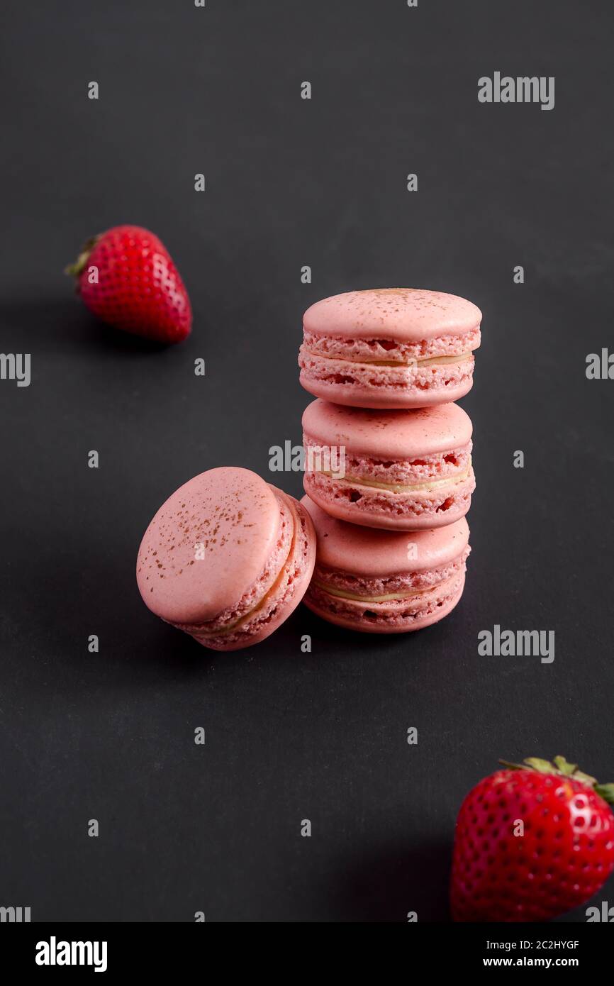 Strawberry macarons on dark background. Macarons are delicate french