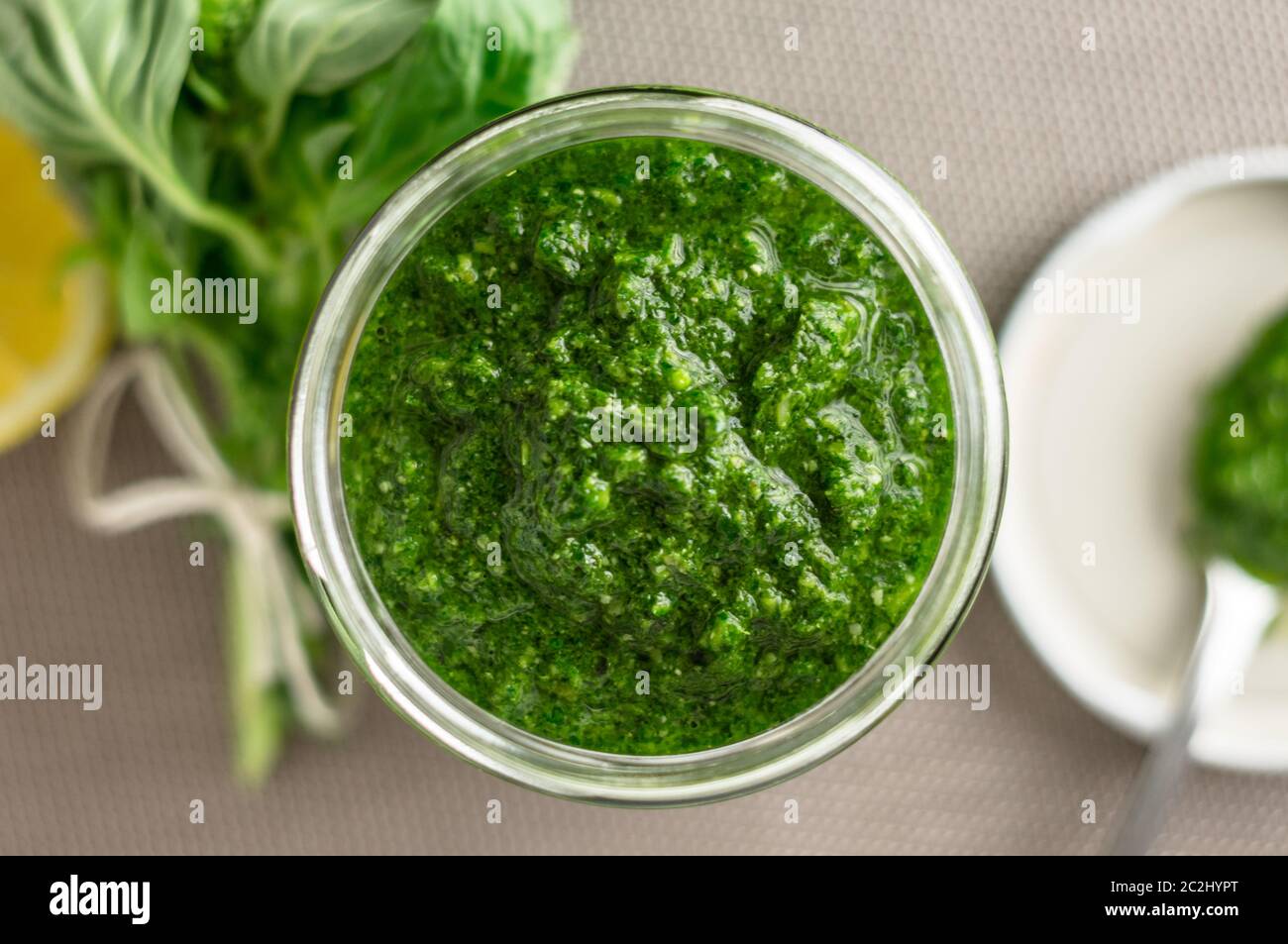 Fresh homemade basil pesto sauce in a glass jar viewed from above. Originally from italy, pesto is commonly made with basil and used as a sauce for pa Stock Photo