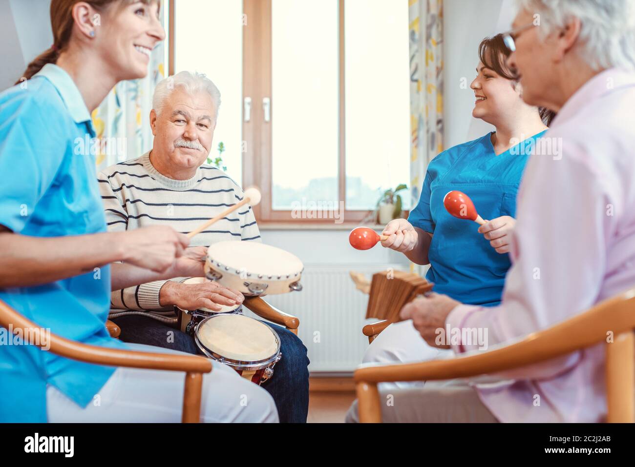 Seniors in nursing home making music with rhythm instruments as musical