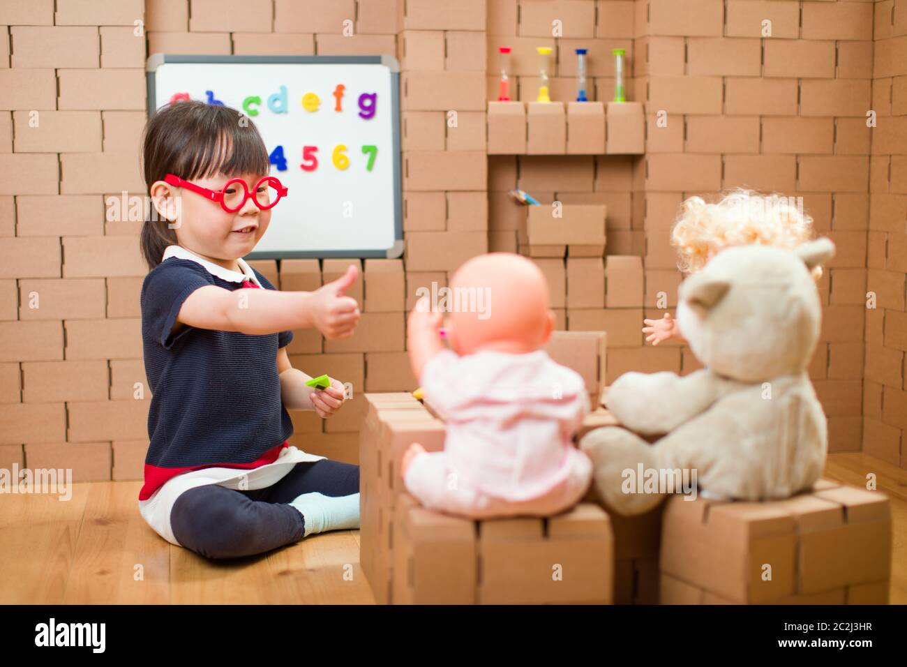 toddler girl pretend play as a teacher at home Stock Photo Alamy