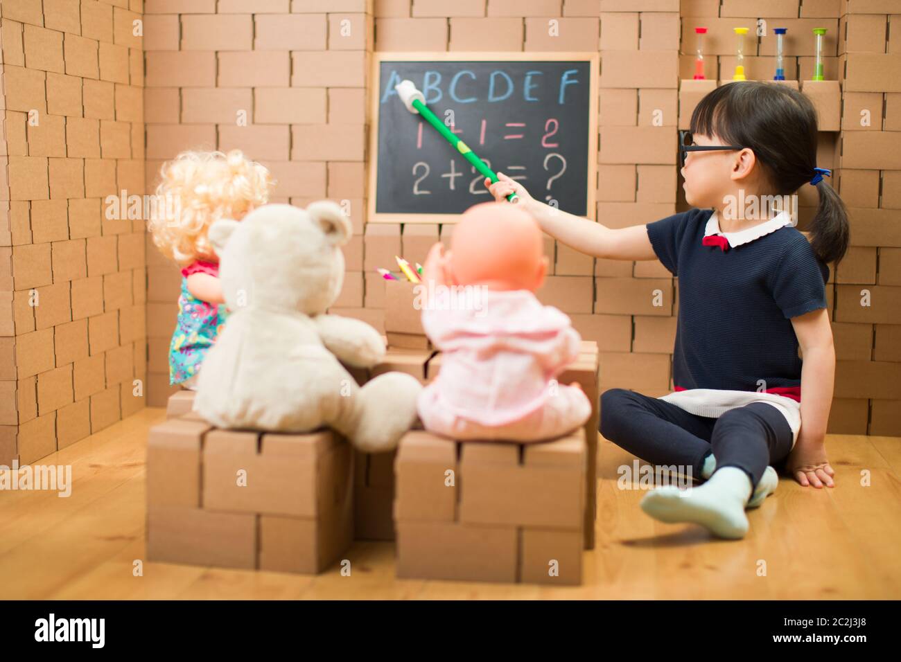 toddler girl pretend play as a teacher at home Stock Photo Alamy