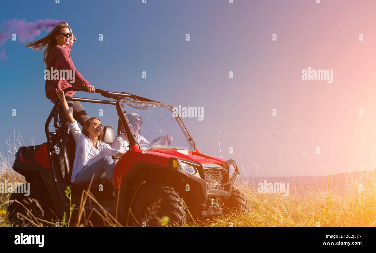 group of young people having fun while driving a off road buggy car ...