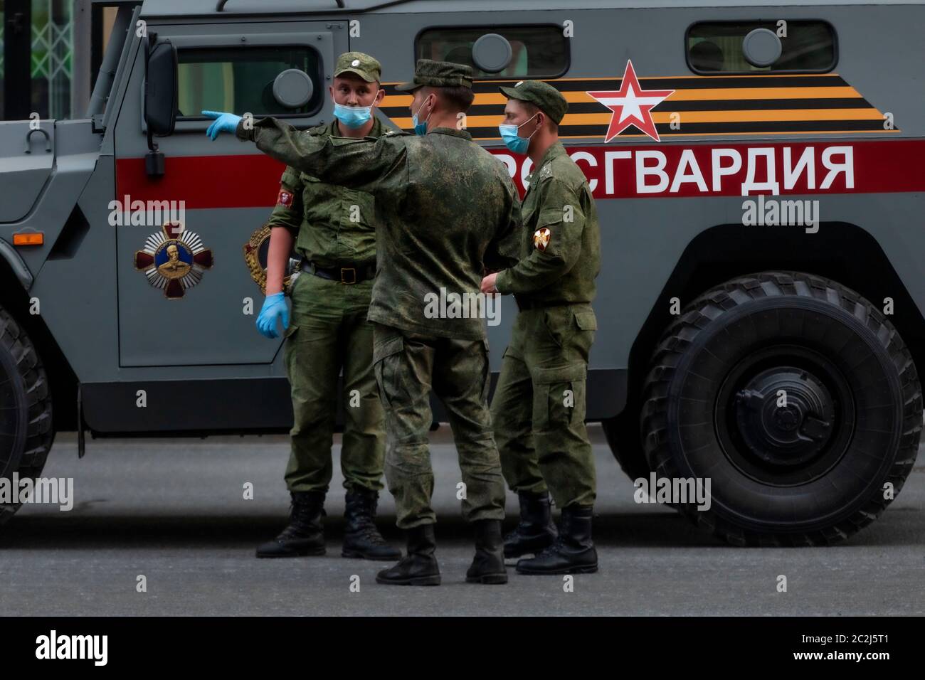 Moscow, Russia. 17th of June, 2020 Russian Rosguardia (National Guard) soldiers wearing face masks and gloves to protect against novel coronavirus, takes part in a rehearsal of a military parade marking the 75th anniversary of Victory in WWII, on Tverskaya street in Moscow, Russia. The inscription on the side of an armored car reads 'Rosguardia' Stock Photo