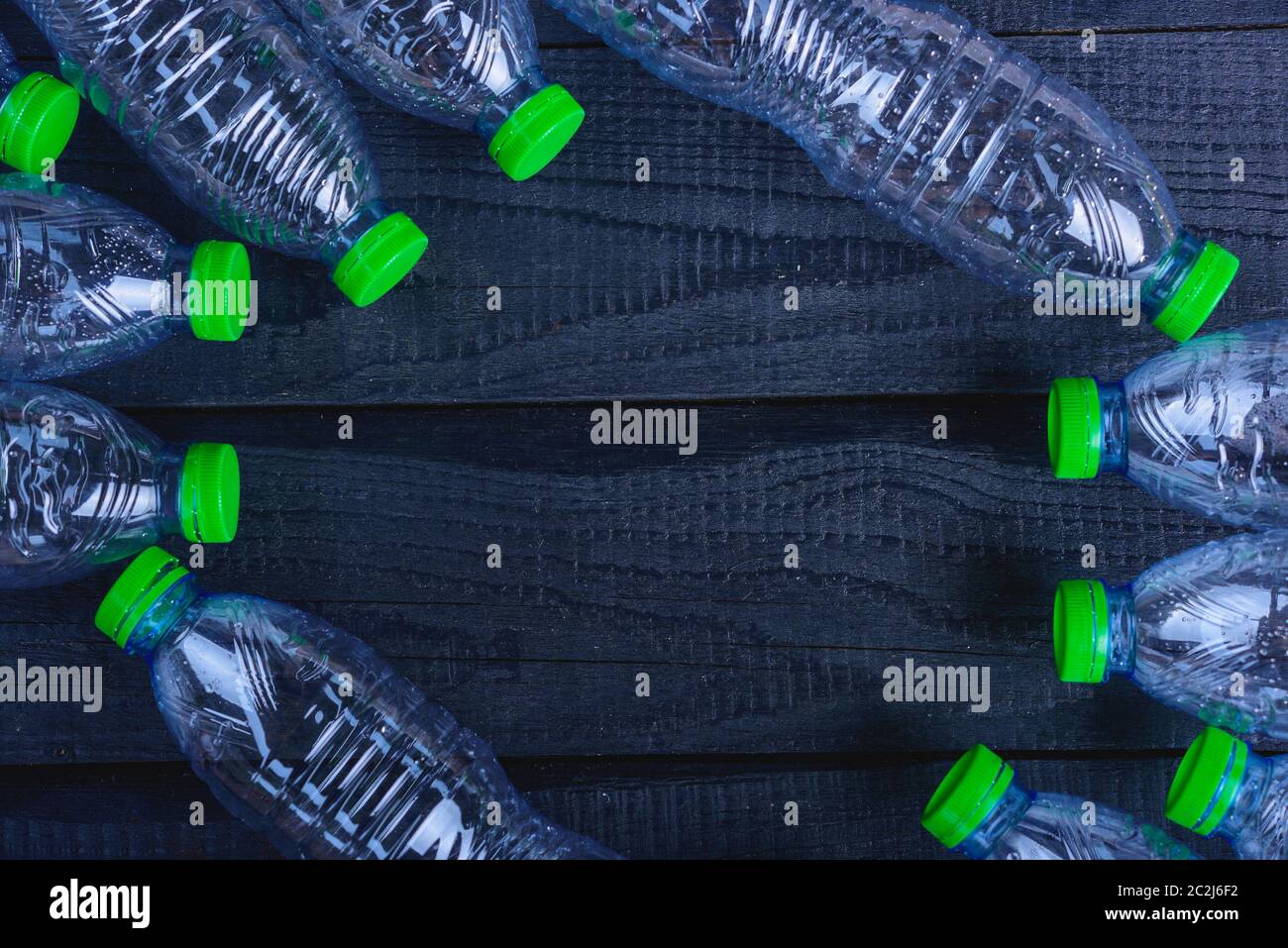 Frame plastic bottles garbage recycled on black wooden, environment concept Stock Photo