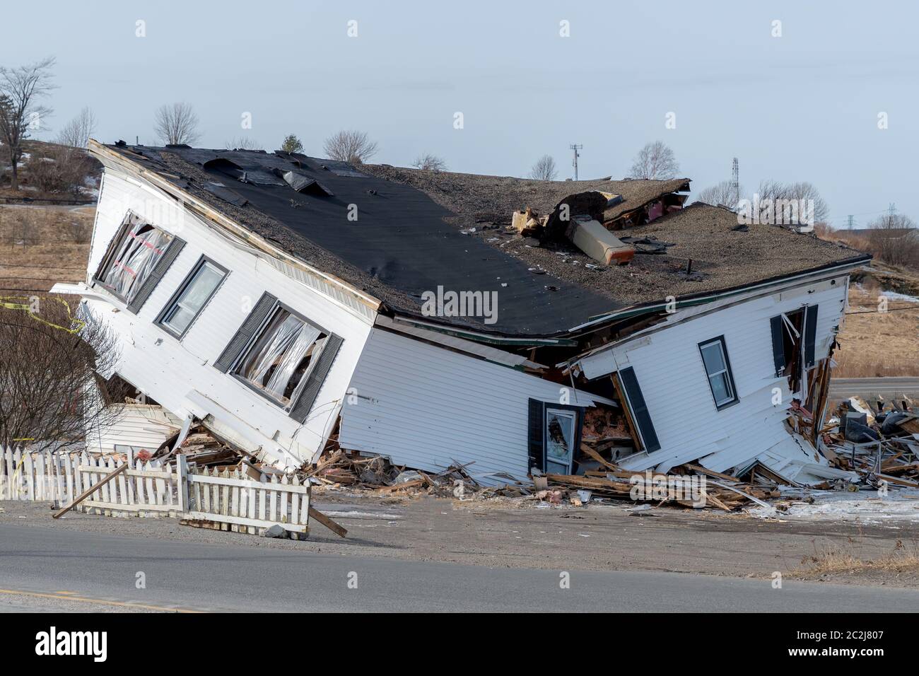 A heavily damaged, collapsing house. The second floor has fallen into