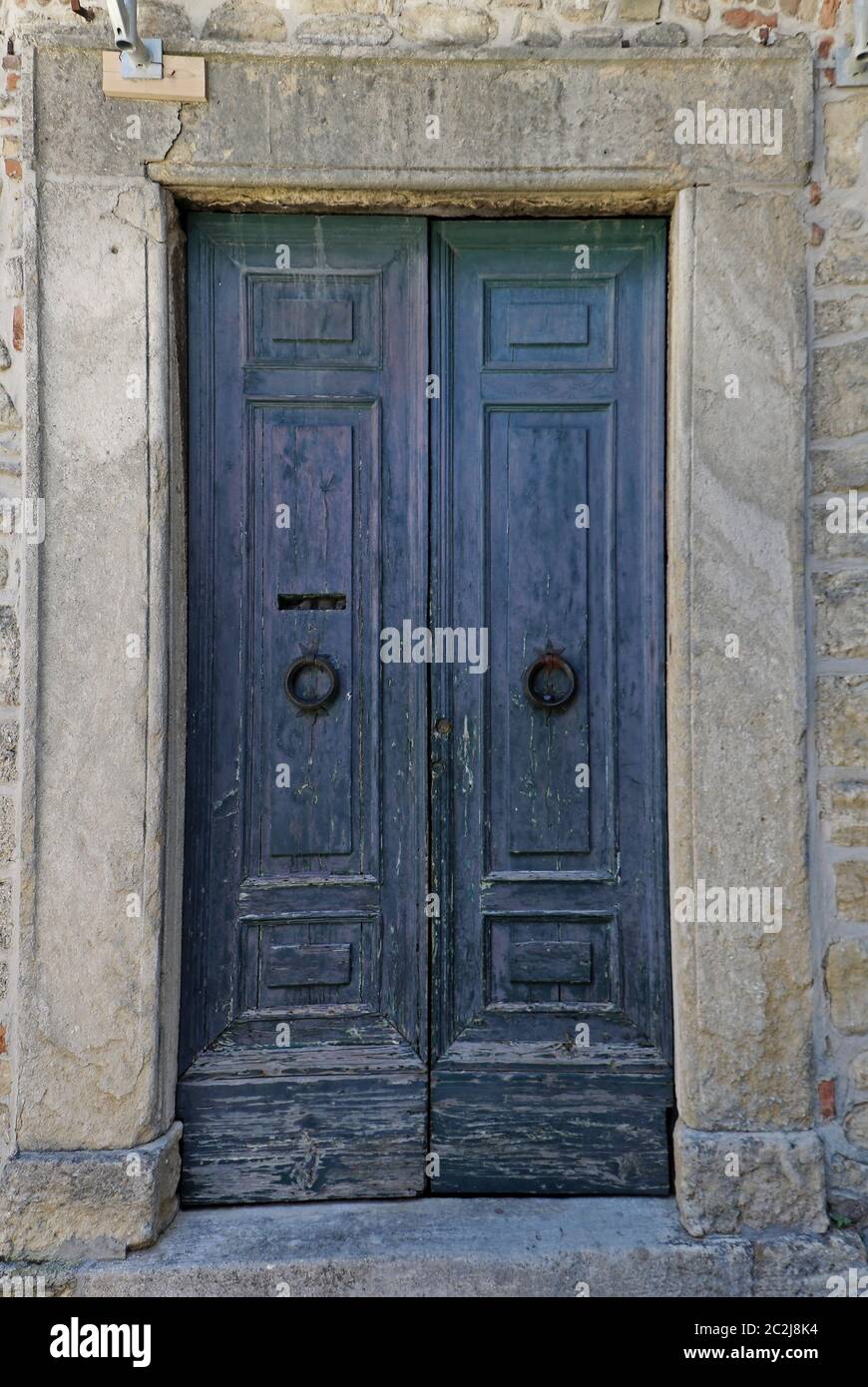 Ancient old blue closed wooden door with stone facade Stock Photo - Alamy