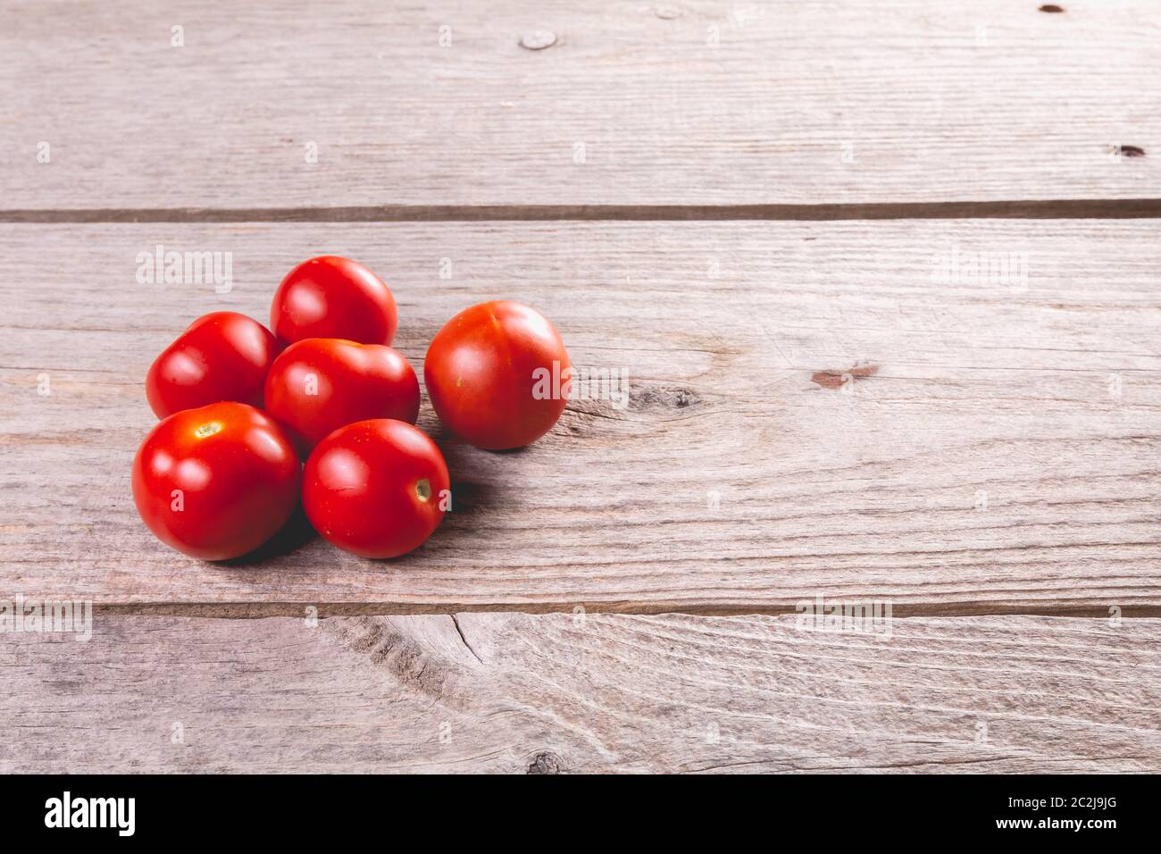 ripe tomatoes on wooden board background in studio Stock Photo - Alamy