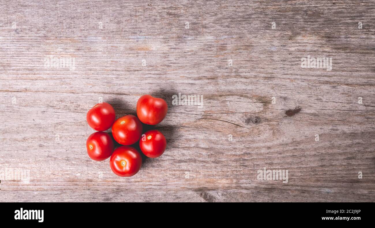 ripe tomatoes on wooden board background in studio Stock Photo - Alamy