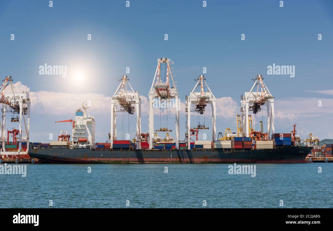 Cranes loading containers on large port cargo transport ship at day ...
