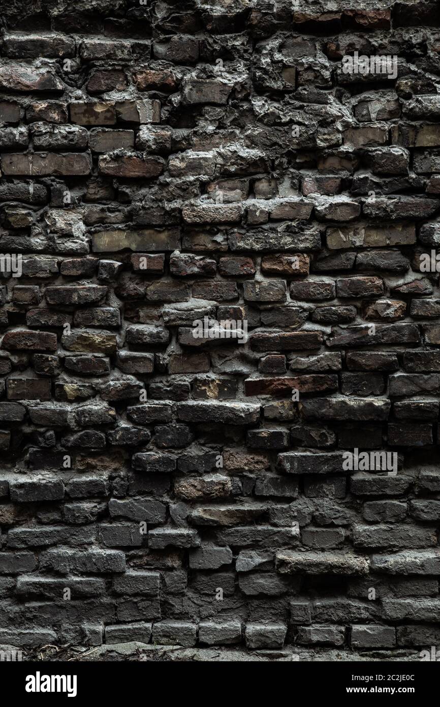 Urban black brick wall texture old masonry background. Gloomy
