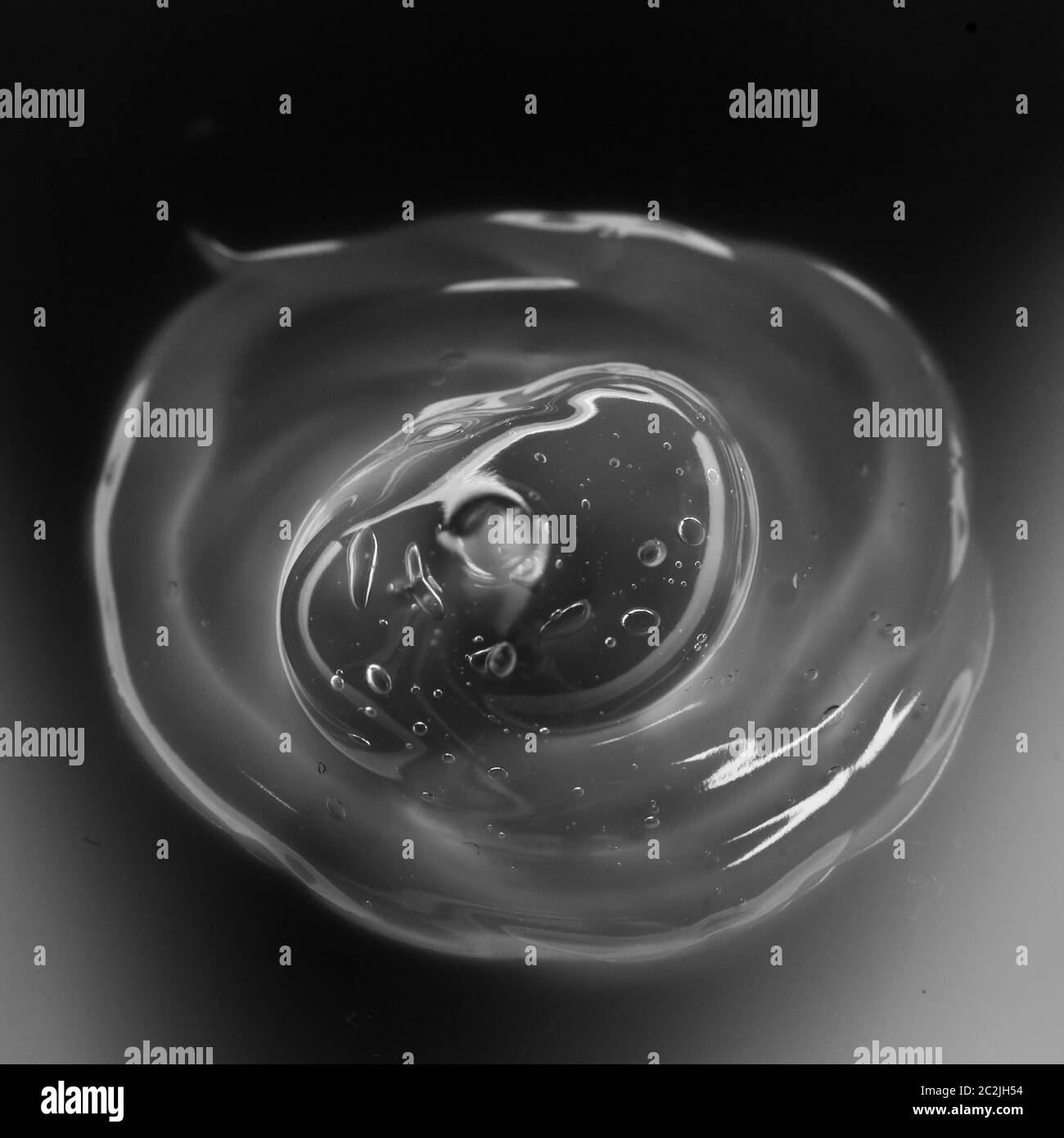 Cream gel transparent cosmetic sample texture with bubbles isolated on black background. Cosmetic cream transparent gel serum te Stock Photo