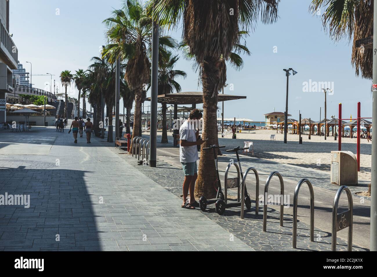 Tel Aviv/Israel-10/10/18: man is renting a Bird e-scooter via the mobile app on his smartphone on a promenade in Tel Aviv. The bird is a micromobility Stock Photo