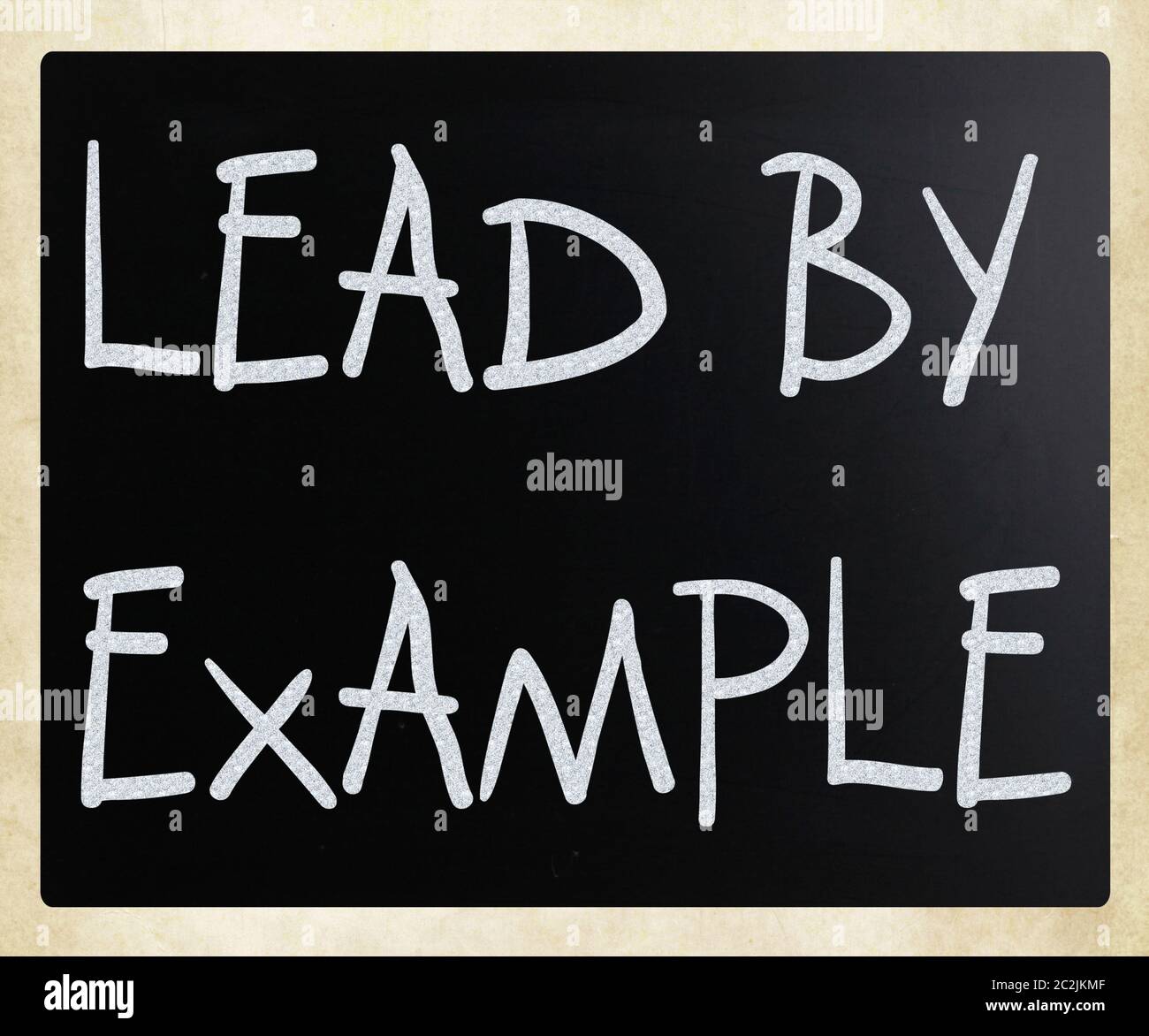 "Lead by example" handwritten with white chalk on a blackboard Stock Photo