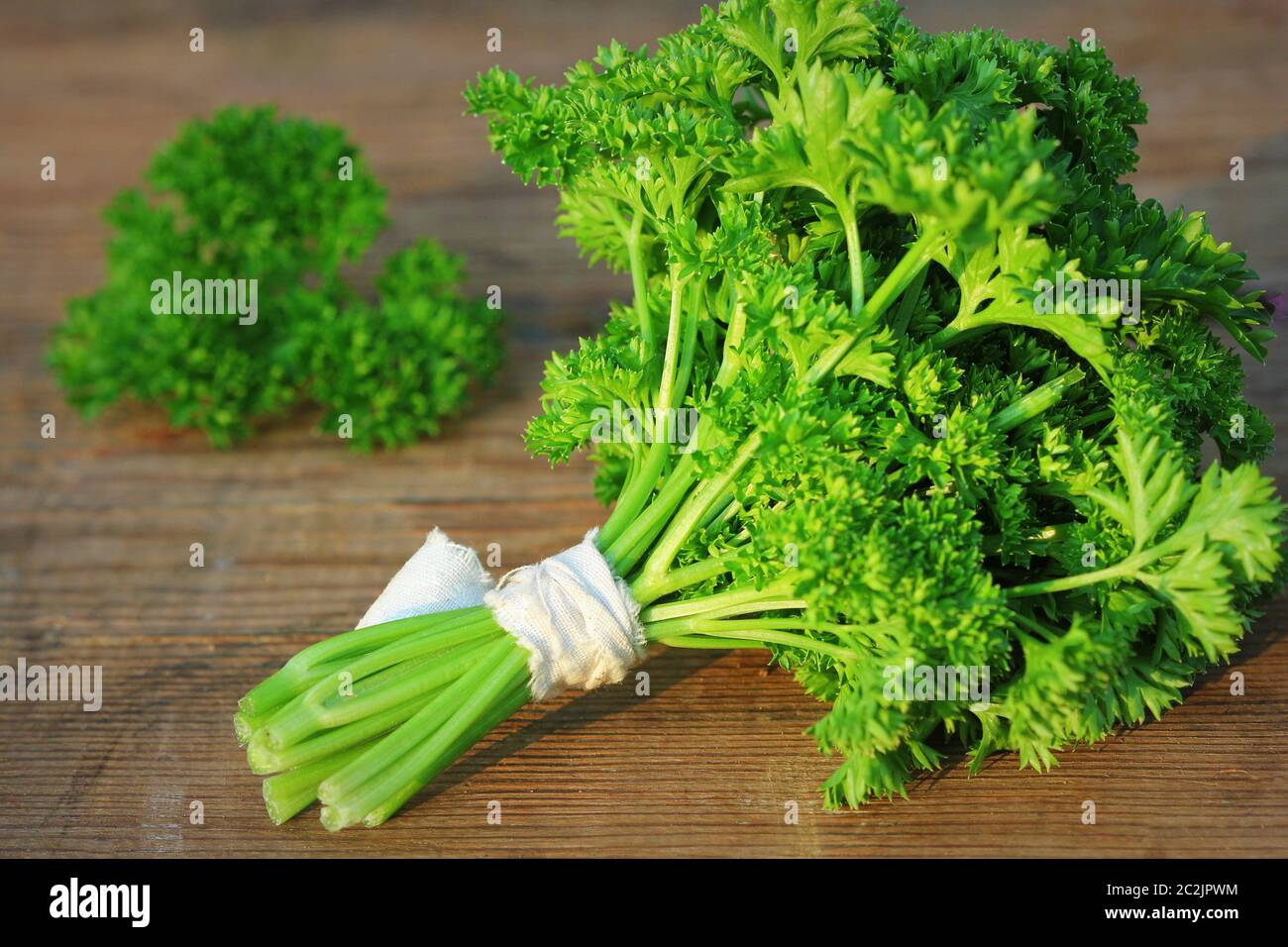 Organic fresh bunch of parsley on a wooden rustic table . Stock Photo