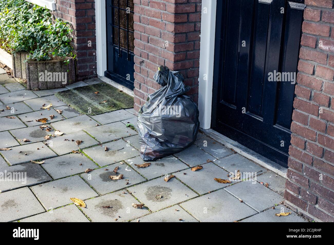 Premium Photo  Pile of black trash bags filled with garbage near brick  wall on the street