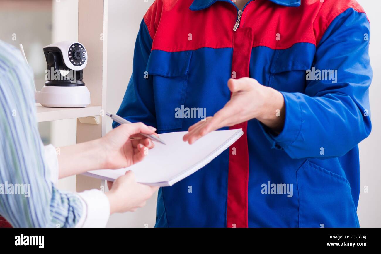 Client getting securty camera installed at home by contractor Stock Photo