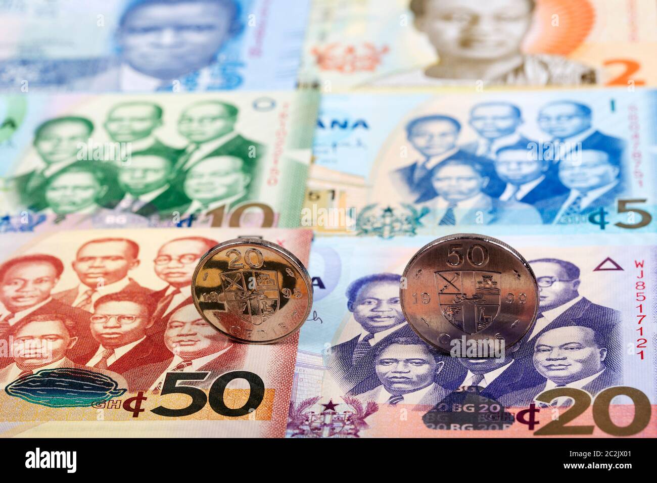 Ghanaian coins on the background of banknotes Stock Photo