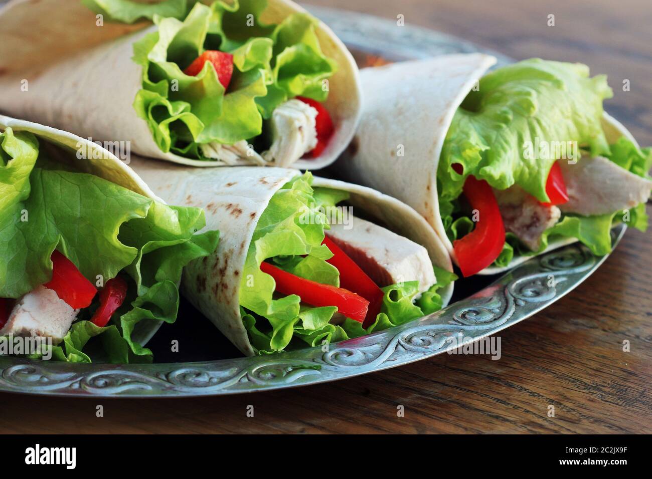 Classic tortilla wrap with grilled chicken and vegetables Stock Photo