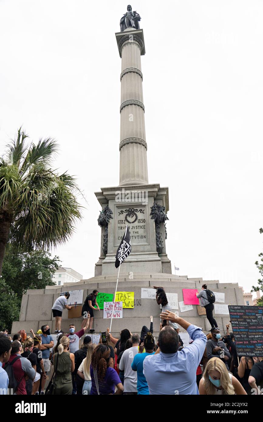 Charleston, United States. 17th June, 2020. Black Lives Matter protesters hang signs on the massive John Calhoun statue in Marion Square on the 5th anniversary of the mass shooting at Mother Emanuel AME Church June 17, 2020 in Charleston, South Carolina. Nine members of the historic African-American church were gunned down by a white supremacist during bible study on June 17, 2015. Credit: Richard Ellis/Alamy Live News Stock Photo
