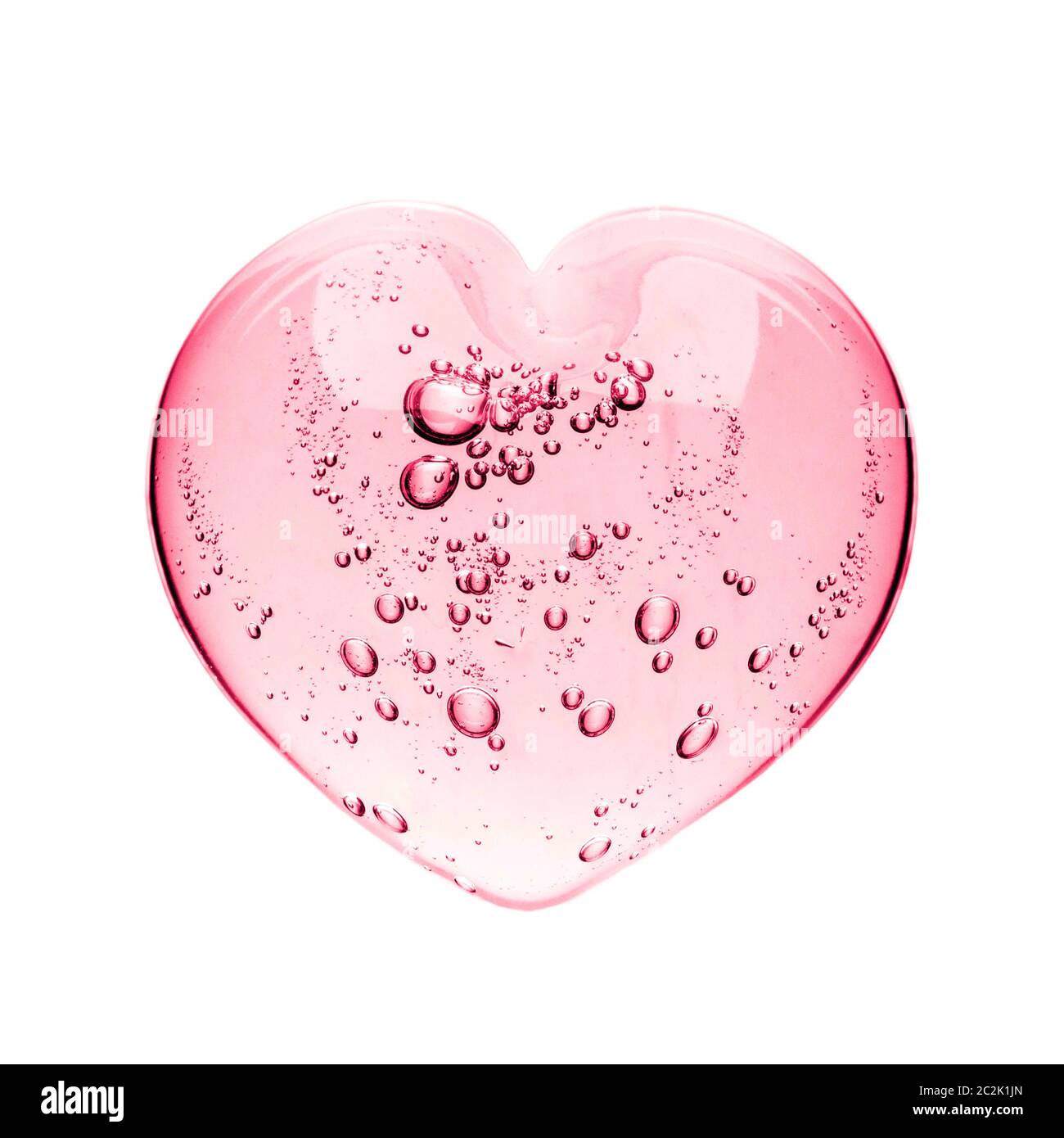 Pink serum gel, heart shape puddle isolated on white backdrop, top view. Squeezed transparent care gel with bubbles close up, ma Stock Photo