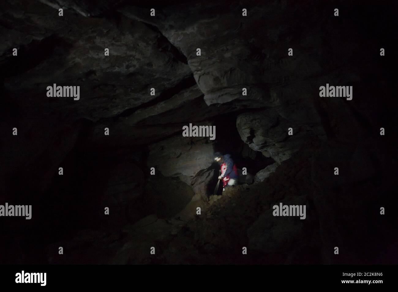 A man moving through the underground cave system of Kalong (bat) Cave in Tangkahan, North Sumatra, Indonesia. Stock Photo