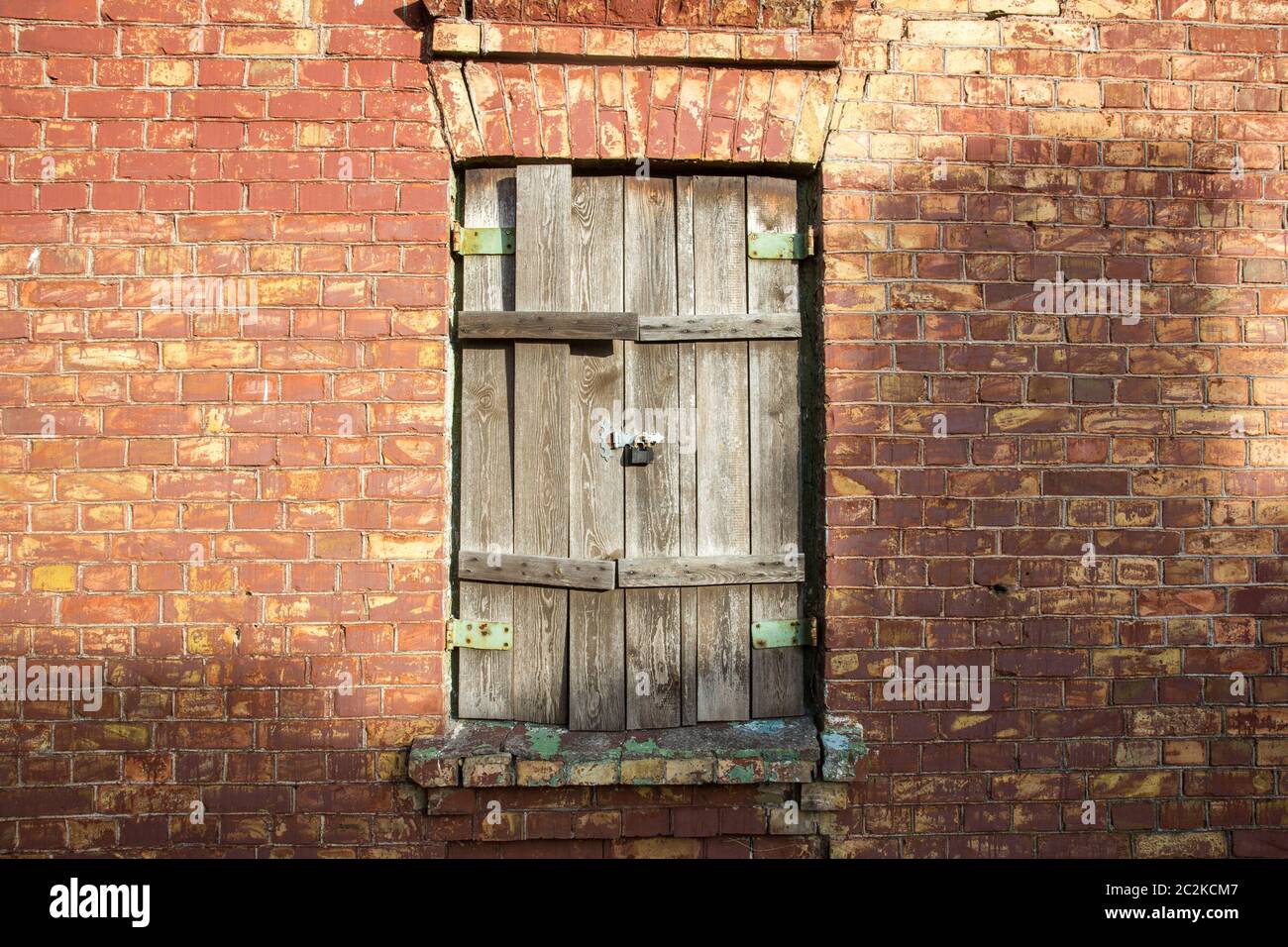 Old wooden window with closed shutters on red brick wall Stock Photo ...