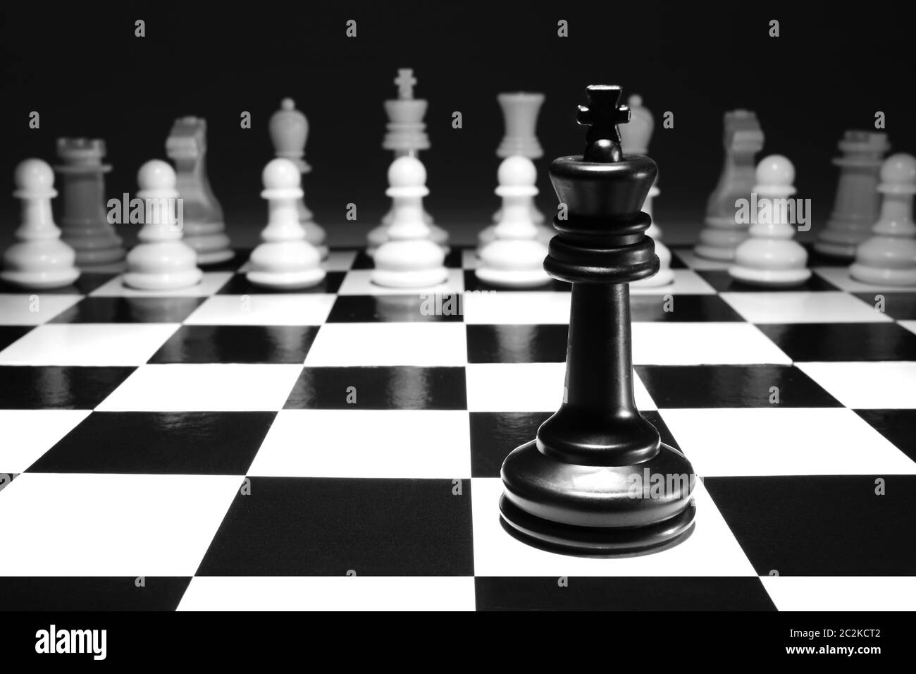 A chess black king single alone against white army concept strategy game one selective focus Stock Photo