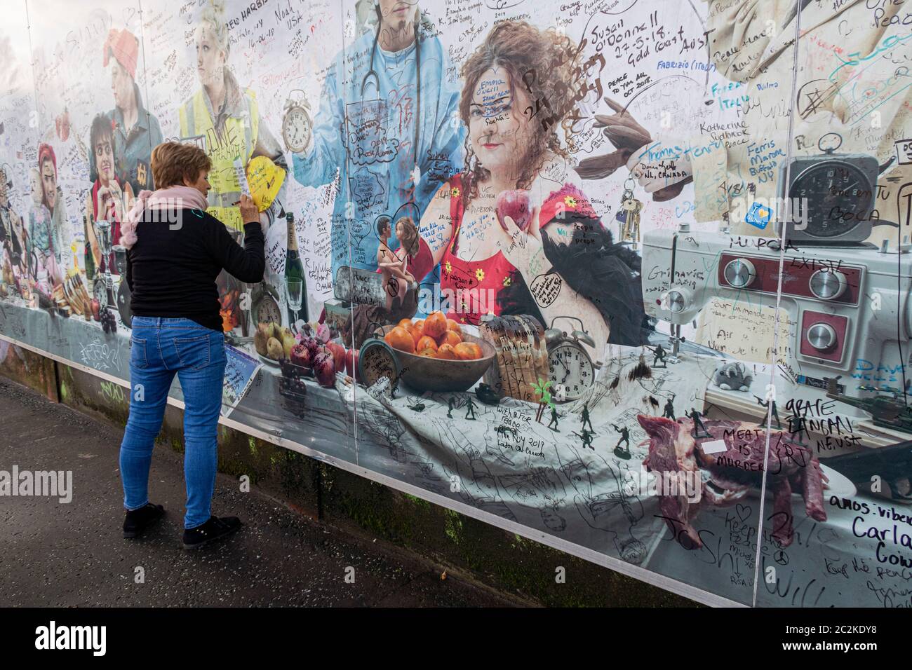 Woman signing the Peace Wall mural in Belfast, Northern Ireland, UK, Europe Stock Photo