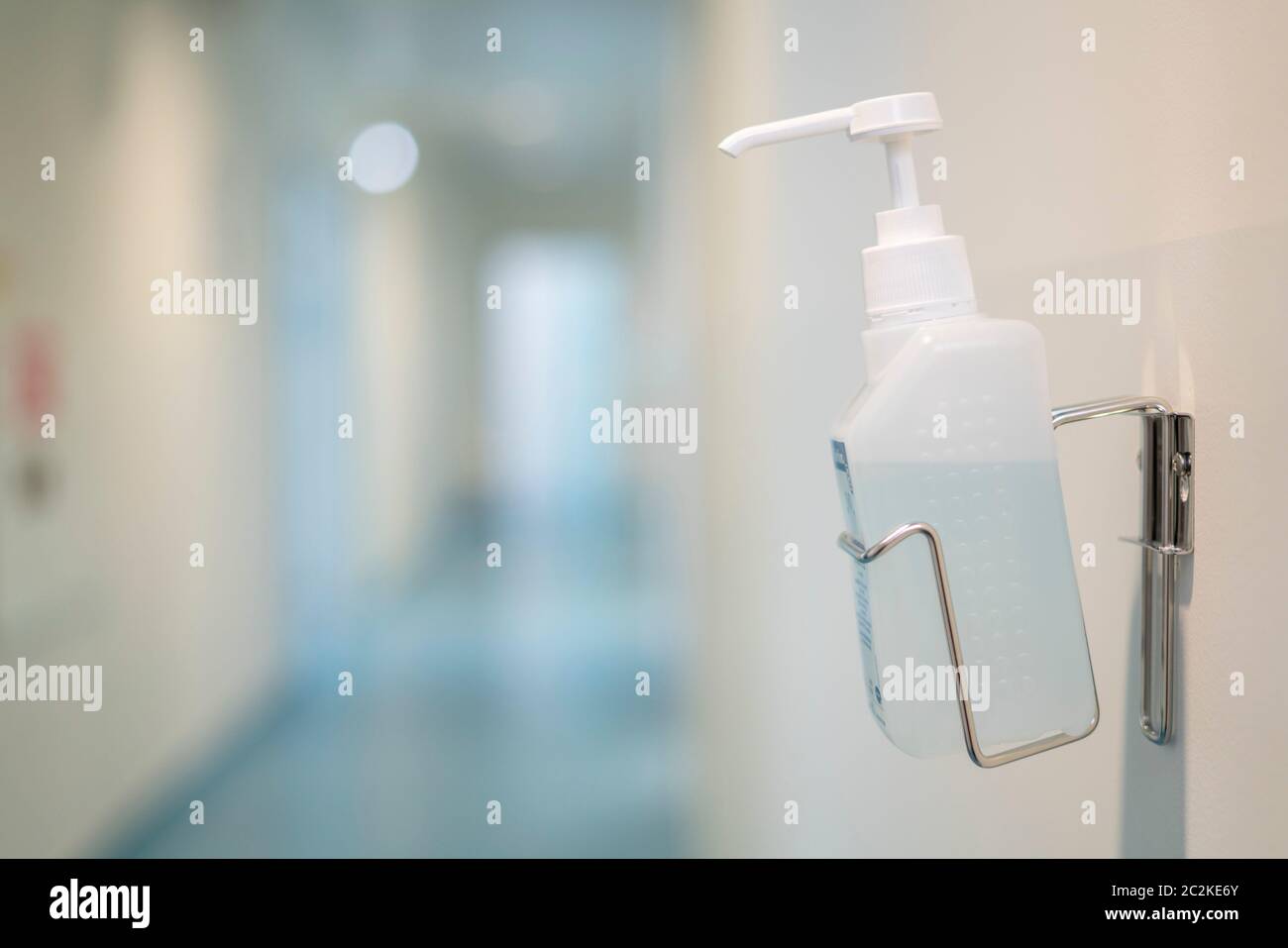 Hand sanitizer gel bottle on the wall of a public space Stock Photo