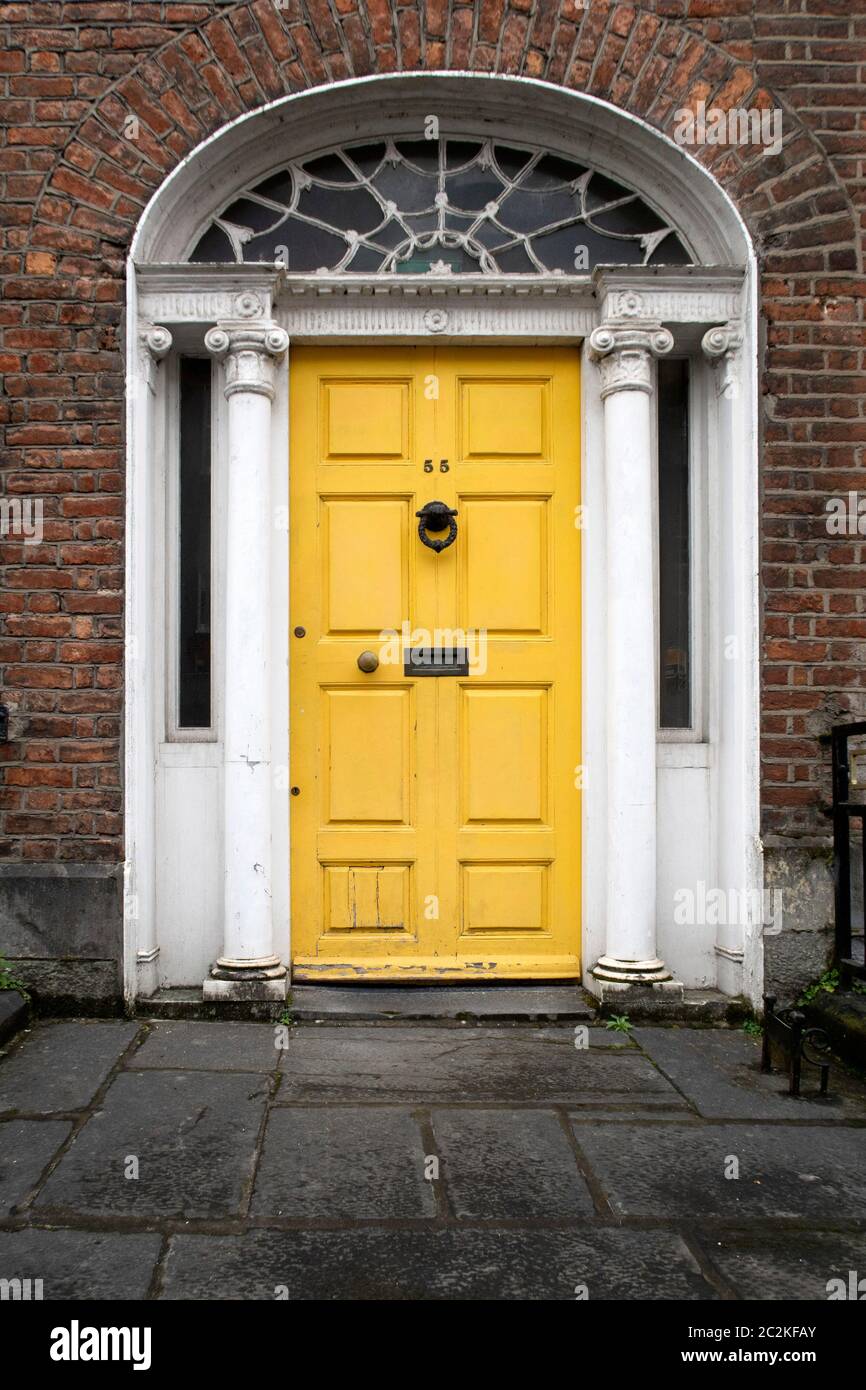 Yellow door on house number 55 Stock Photo