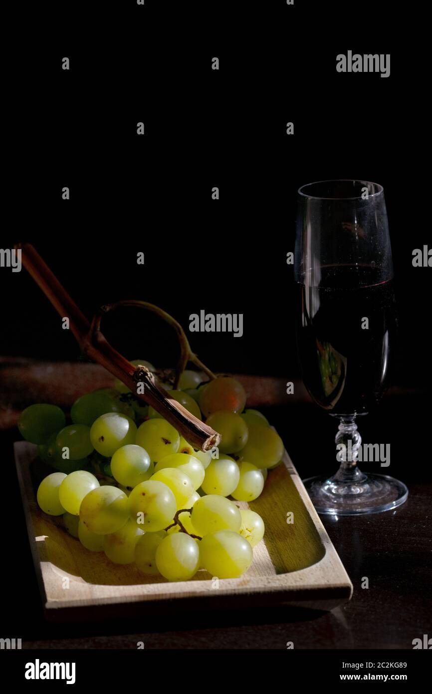 grape harvest concept with bunch of grapes and a glass of red wine
