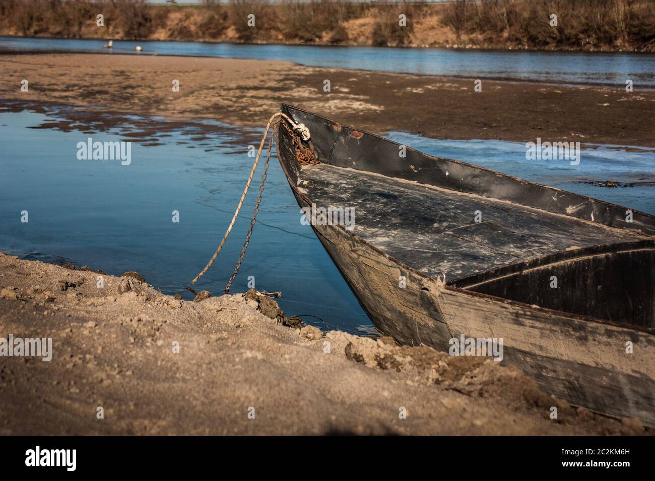 An old wooden boat abandoned on the banks of water going in Italy Stock ...