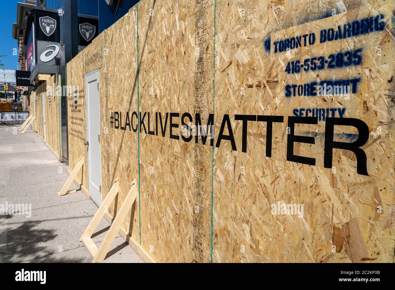 Boarded up storefront in Downtown Toronto showing Black Lives Matter message written out front in support of social movement against racial injustice. Stock Photo