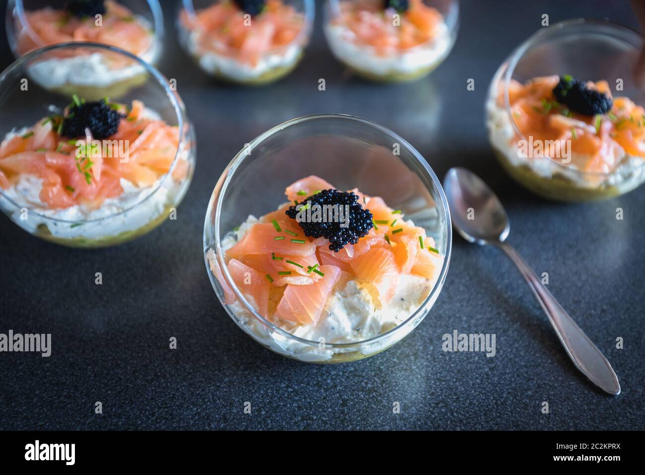 verrine salmon lumpfish egg fresh cheese and avocado bed in the kitchen Stock Photo