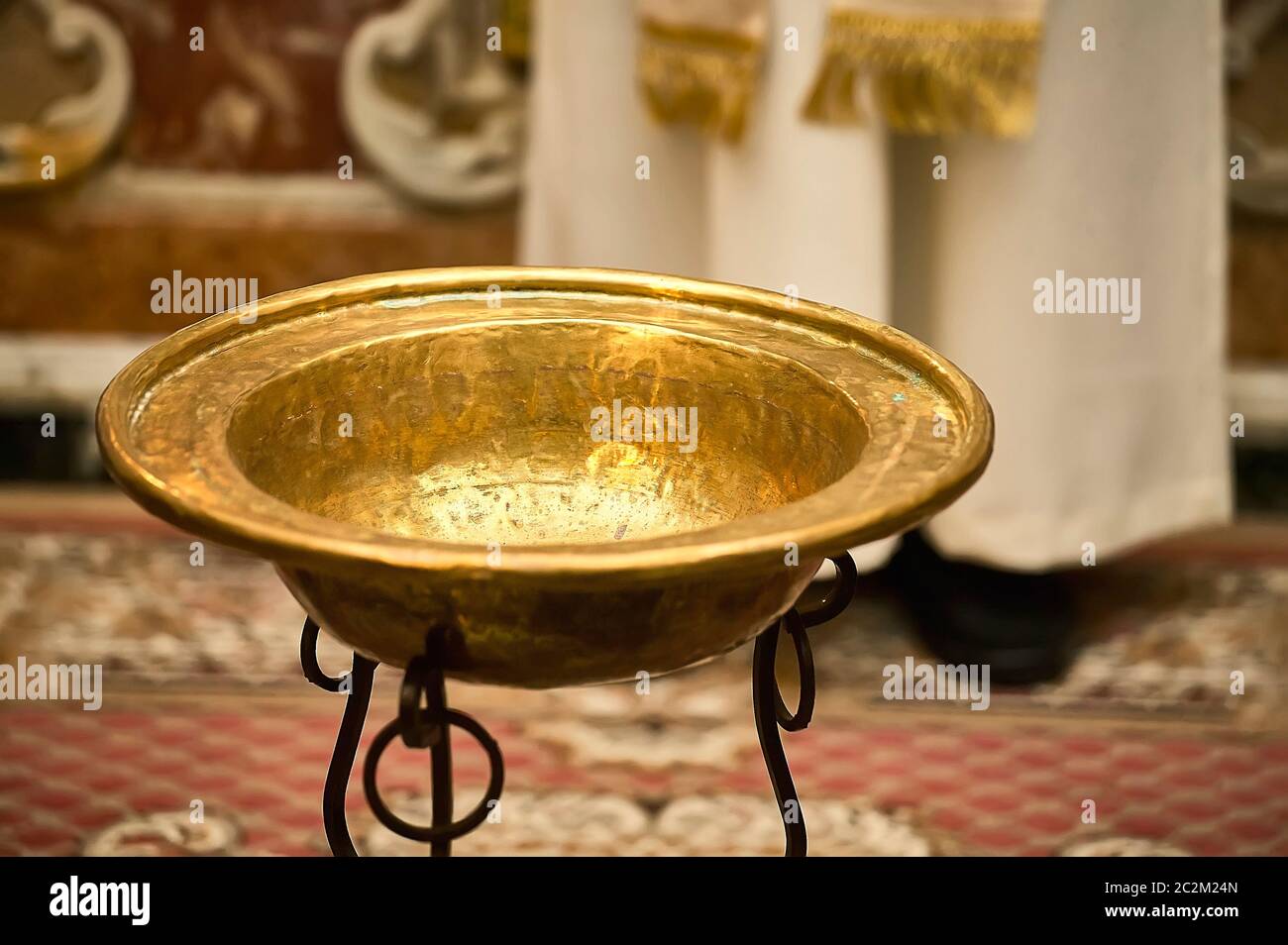 Evocative image of Catholic baptism with the golden bowl to put the