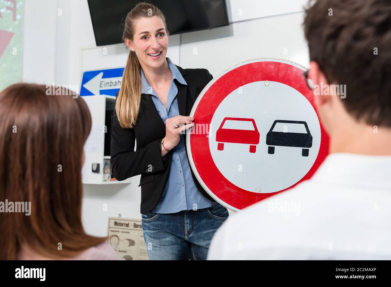 Driving instructor explaining meaning of street sign to class of ...