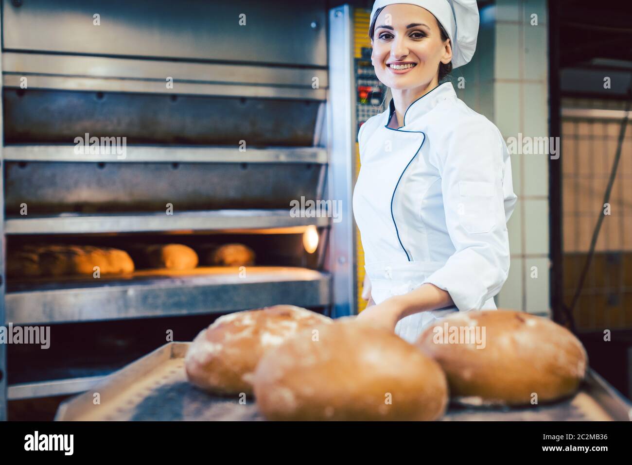 https://c8.alamy.com/comp/2C2MB36/baker-woman-showing-freshly-baked-bread-on-shovel-one-can-almost-sniff-the-freshness-2C2MB36.jpg