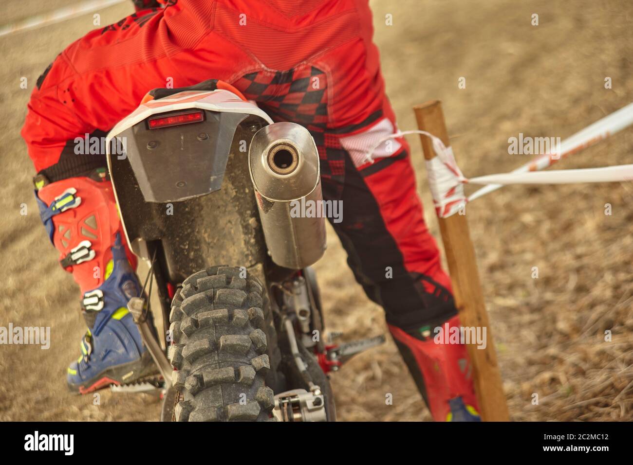 Detail of the back of a cross bike with the rider in the saddle ready to go for the race Stock Photo