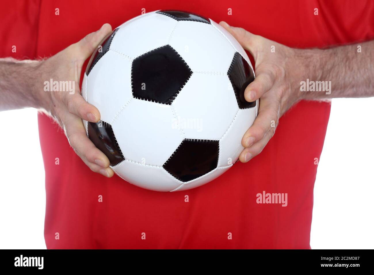 keeper with red shirt is holding a soccer ball Stock Photo