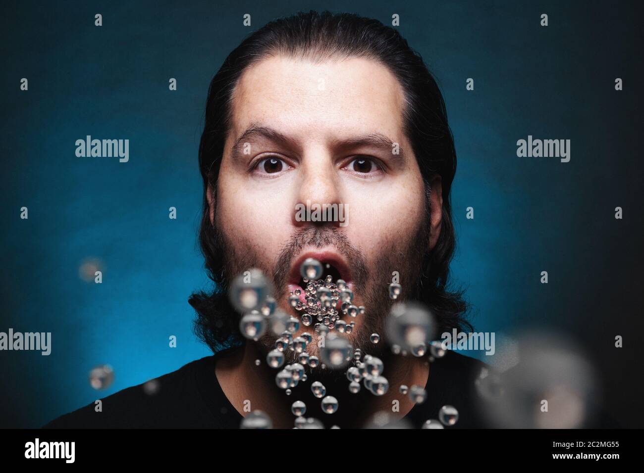 Man with open mouth exhaling or inhaling plastic particles