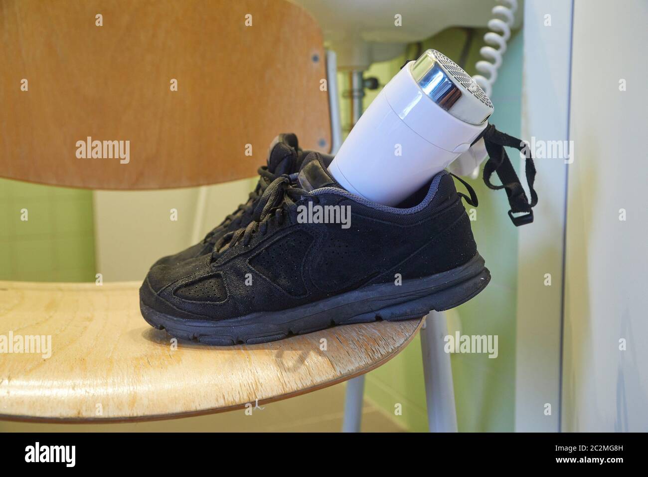 Drying wet shoes with a hairdryer after soaking rain Stock Photo Alamy