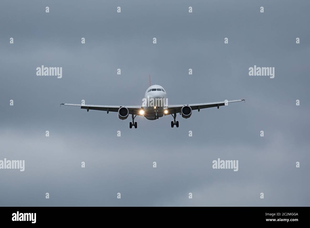Plane approaching with landing lights Stock Photo - Alamy