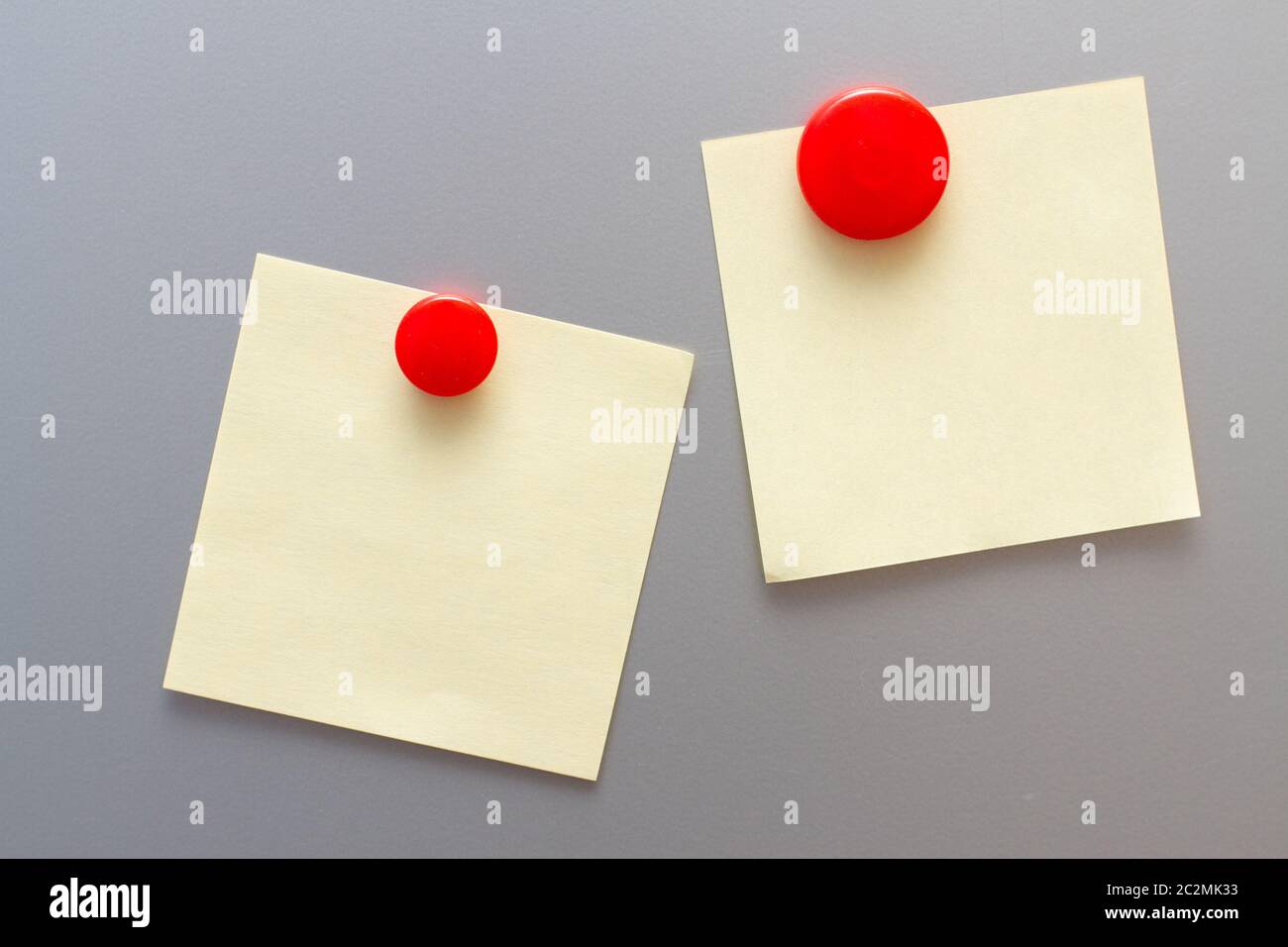 Yellow empty stickers attached red magnet on fridge Stock Photo