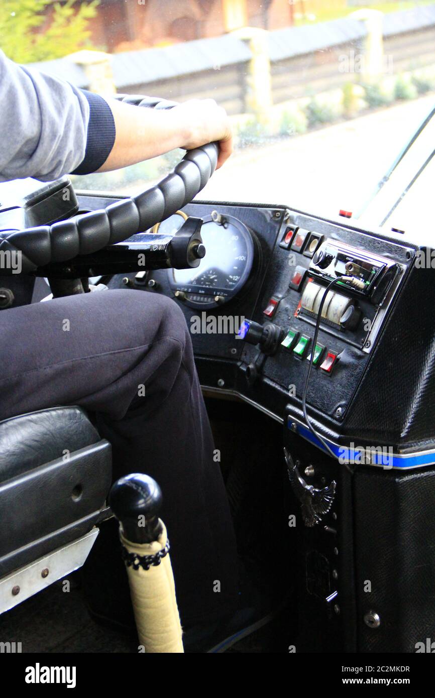 Driver is driving bus. Driver switching gear lever in bus. Dashboard in